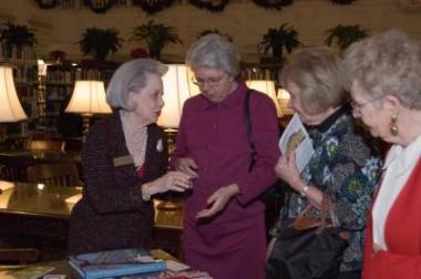 responding Secretary General Florence Patton (far left) shows guests the items on sale at the DAR Store.