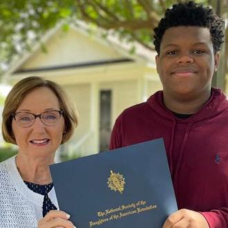 Lady presenting boy with an academic scholarship