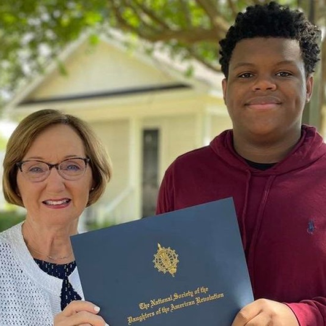 Lady presenting boy with an academic scholarship