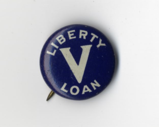 Navy blue liberty loan pin with lettering: “Liberty Loan V,” circa 1918.