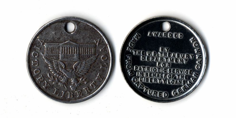 Two silver “Victory Liberty Loan” medallions with the image of eagle and state building on the front. The back reads: “Awarded by the U.S. Treasury Department for Patriotic Service on Behalf of the Liberty Loans – Made from Captured German Cannon,” 1918.