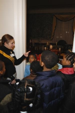 A volunteer DAR Museum Docent explained to children details about one of the historic period rooms.