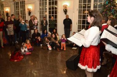 Children found a spot on the floor to enjoy carols from Adventure Theatre.