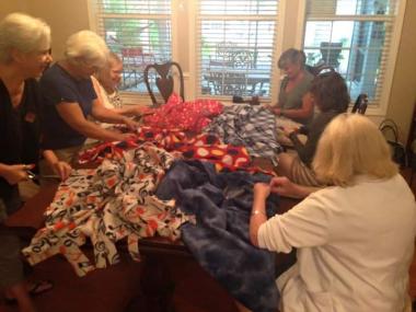 Several tables just like this one of Emily Geiger chapter South Carolina members making lap robes for a local veterans home for National Day of Service.
