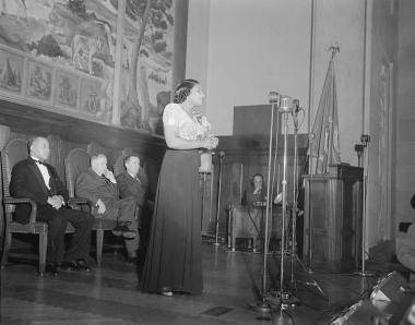 January 6, 1943 -- Marian Anderson sings in the U.S. Department of the Interior auditorium during the dedication ceremony of the mural painting commemorating a free public concert given by her on the steps of the Lincoln Memorial on April 9, 1939.
