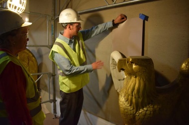 A Project Superintendant from Christman Co. shows the President General an example of how the neutral toned paint colors will make the newly painted white eagles contrast from the wall.