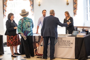 Several people interacting at a table at the Symposium. 