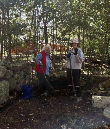 Members pose with rakes. 