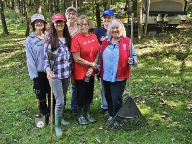 Members pose with rakes. 