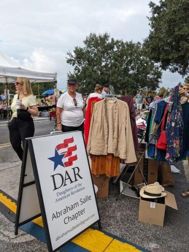 Members sell clothes at a vintage clothes stand. 