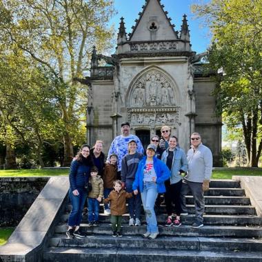 Members pose in front of a mausoleum.