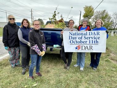 A group of members pose in front of a truck that they used to hlep