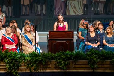 A girl giving a speech at a podium.