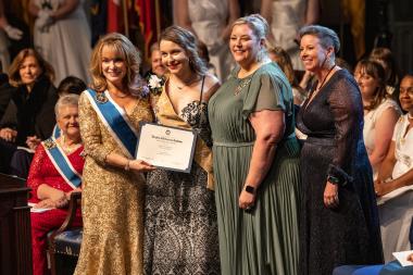 Woman with award and execs pose for photo