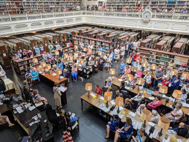 People in library listen while someone gives a speech.