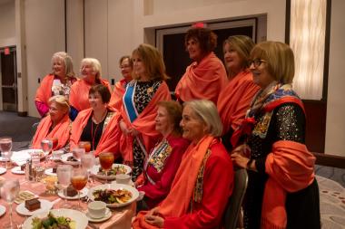 Women in shawls at a dinner 