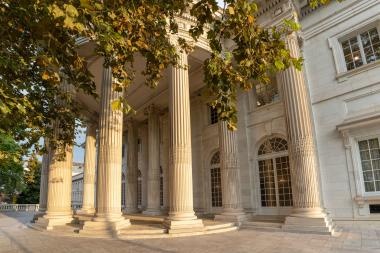 Front view of grand white building with columns.