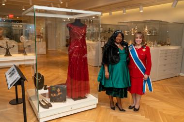 The President General and Jillian Pirtle, CEO of the Marian Anderson Museum, stand in front of one of Marian Anderson's gowns in the DAR Museum.