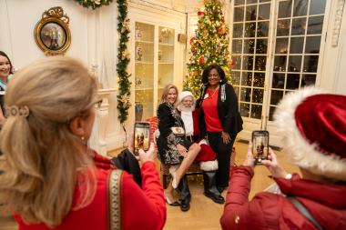 Two women getting their picture taken with Santa. 