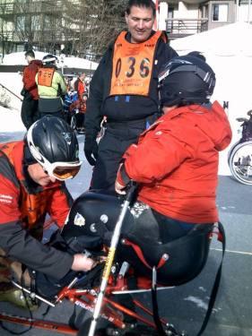 Volunteers help this participant with the skiing equipment.